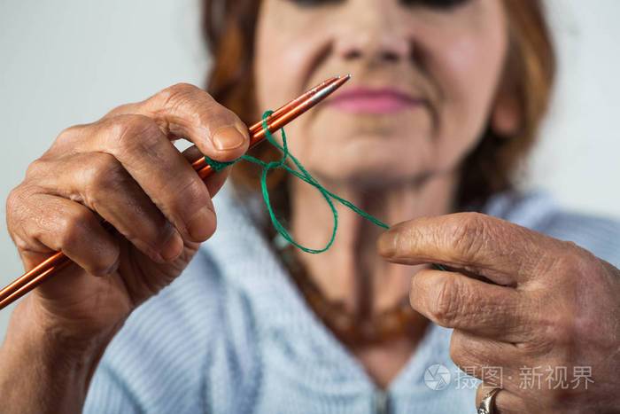 编织优雅的老妇人手里拿着针和羊毛闲暇时织毛衣退休女士针织品和手工